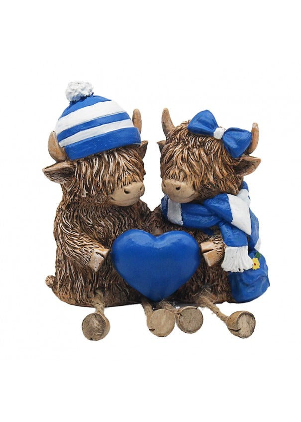 The Highland Cows With Blue Hat And Scarf Holding Heart